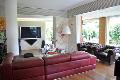 Источник вдохновения для домашнего уюта: большая открытая гостиная комната в стиле модернизм с белыми стенами, светлым паркетным полом и телевизором на стене