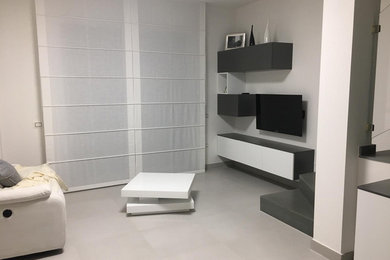 Immagine di un soggiorno moderno di medie dimensioni e aperto con pareti bianche, TV autoportante e pavimento bianco