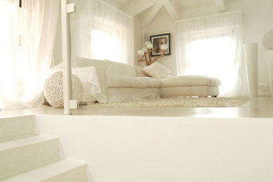 Esempio di un soggiorno stile marinaro con pareti bianche, pavimento in cemento e pavimento bianco
