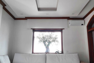Esempio di un grande soggiorno minimalista aperto con pareti bianche, pavimento in legno massello medio, nessun camino, pavimento marrone e soffitto ribassato