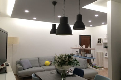 Foto de salón para visitas abierto contemporáneo de tamaño medio sin chimenea con paredes blancas, suelo de baldosas de porcelana y pared multimedia