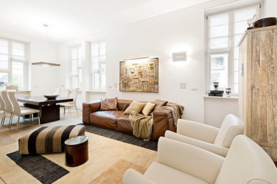 Ejemplo de salón abierto minimalista de tamaño medio con paredes blancas y suelo de madera clara