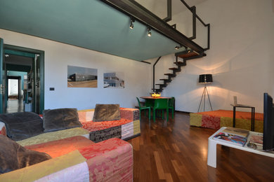 Imagen de sala de estar tipo loft actual de tamaño medio con suelo de madera oscura