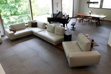 Foto di un ampio soggiorno moderno aperto con sala della musica, pavimento in gres porcellanato, TV autoportante e pavimento grigio