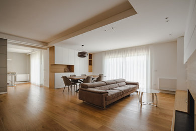 Ejemplo de salón minimalista con suelo de madera oscura, todas las chimeneas, marco de chimenea de madera y televisor independiente