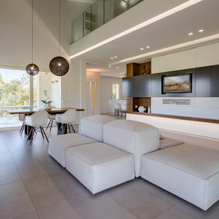 Esempio di un ampio soggiorno minimal stile loft con pareti bianche, pavimento grigio e travi a vista