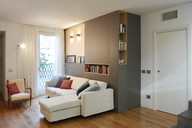 Ejemplo de salón abierto actual de tamaño medio sin chimenea con paredes blancas y suelo de madera clara