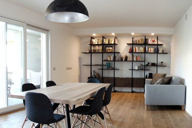 Idee per un soggiorno minimal di medie dimensioni e aperto con libreria, pareti bianche, parquet chiaro e TV a parete