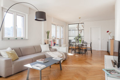 Idee per un soggiorno scandinavo aperto con pareti bianche, pavimento in legno massello medio, TV autoportante e pavimento marrone