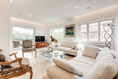 Immagine di un ampio soggiorno contemporaneo aperto con pareti bianche, parquet chiaro, cornice del camino in intonaco, pavimento beige e TV autoportante