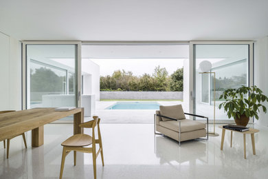 Idee per un grande soggiorno design aperto con pareti bianche, TV nascosta, pavimento bianco e boiserie
