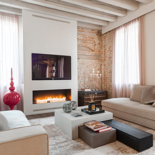 Esempio di un soggiorno contemporaneo aperto con pareti beige, camino classico, TV a parete e cornice del camino in intonaco