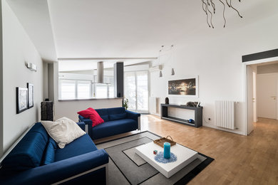 Foto di un soggiorno minimalista di medie dimensioni e aperto con pareti bianche, parquet chiaro, parete attrezzata e pavimento beige