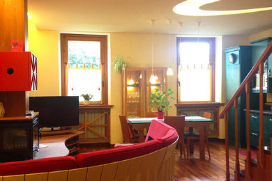 Immagine di un soggiorno moderno di medie dimensioni e chiuso con pavimento in legno massello medio, camino ad angolo, cornice del camino in legno e TV autoportante