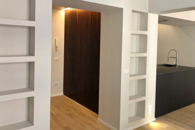 Idee per un soggiorno design di medie dimensioni e aperto con libreria, pareti grigie, pavimento in legno massello medio, TV a parete e pavimento beige
