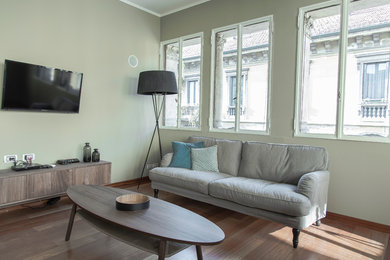 Ispirazione per un soggiorno scandinavo di medie dimensioni e aperto con pareti beige, parquet chiaro e TV a parete