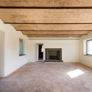 Idee per un piccolo soggiorno country chiuso con pareti bianche, pavimento in mattoni, camino classico, cornice del camino in pietra, pavimento rosa, soffitto a volta e pannellatura