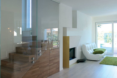 Diseño de salón actual con paredes blancas, suelo de madera pintada, estufa de leña, marco de chimenea de metal y suelo beige