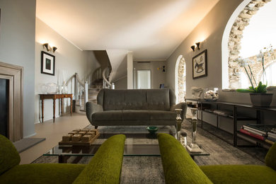 Esempio di un ampio soggiorno design aperto con sala formale, pareti grigie, camino classico, cornice del camino in metallo e TV a parete