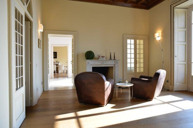 Diseño de sala de estar ecléctica con paredes beige, suelo de madera en tonos medios, todas las chimeneas y suelo marrón