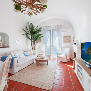 Idee per un grande soggiorno mediterraneo aperto con sala formale, pareti bianche, camino classico, cornice del camino in intonaco, parete attrezzata, pavimento marrone e soffitto a volta