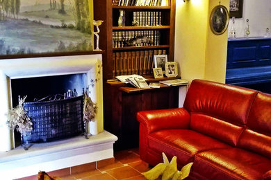 Foto di un grande soggiorno bohémian aperto con pareti bianche, pavimento in terracotta, camino classico, cornice del camino in pietra e TV nascosta