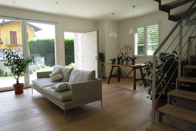 Example of a small trendy enclosed light wood floor and beige floor family room design in Other with white walls