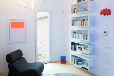Ispirazione per un piccolo soggiorno contemporaneo aperto con libreria, pareti bianche, parquet chiaro, nessuna TV e pavimento beige