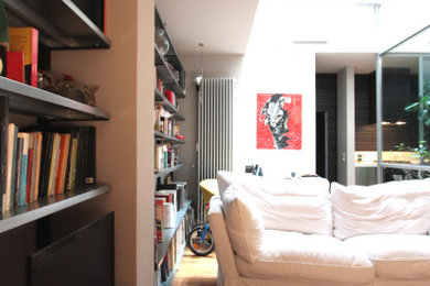 Idee per un piccolo soggiorno moderno stile loft con pareti grigie, parquet chiaro, parete attrezzata e travi a vista