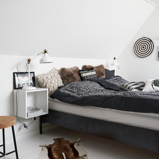 Immagine di una camera da letto scandinava con pareti bianche e pavimento in legno verniciato