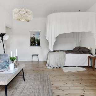 Inspiration för ett minimalistiskt sovrum, med vita väggar, ljust trägolv och beiget golv