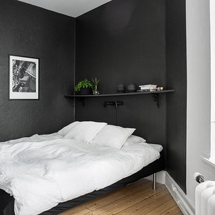 Diseño de dormitorio principal, nórdico, de tamaño medio, sin chimenea, con paredes negras y suelo de madera en tonos medios