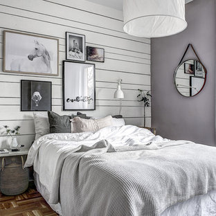 Klassisches Hauptschlafzimmer ohne Kamin mit lila Wandfarbe und braunem Holzboden in Stockholm