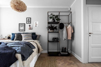 На фото: хозяйская спальня среднего размера в скандинавском стиле с серыми стенами и паркетным полом среднего тона