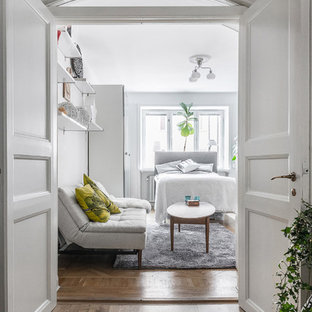 Bild på ett mellanstort minimalistiskt sovrum, med vita väggar, mellanmörkt trägolv och brunt golv