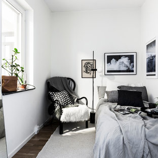 Diseño de habitación de invitados nórdica con paredes blancas y suelo de madera oscura