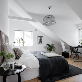 Idéer för att renovera ett mellanstort minimalistiskt gästrum, med vita väggar, ljust trägolv och beiget golv