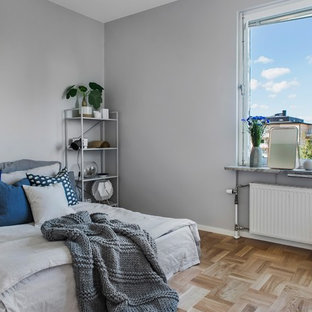 Foto på ett minimalistiskt gästrum, med grå väggar, ljust trägolv och beiget golv