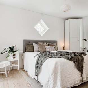 Foto på ett mellanstort minimalistiskt sovrum, med vita väggar, ljust trägolv och beiget golv