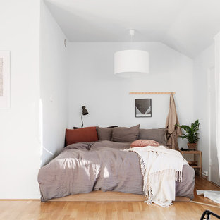 Exempel på ett litet minimalistiskt huvudsovrum, med vita väggar, ljust trägolv och beiget golv