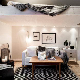 Idée de décoration pour une petit chambre mansardée ou avec mezzanine nordique avec un mur blanc et un sol en bois clair.