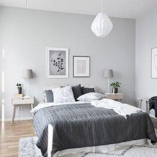 Idéer för ett skandinaviskt gästrum, med grå väggar, mellanmörkt trägolv och brunt golv