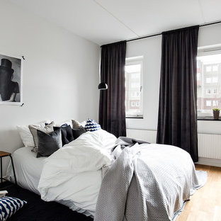 Exempel på ett skandinaviskt huvudsovrum, med vita väggar och ljust trägolv