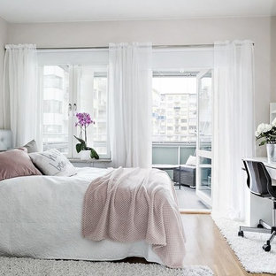 Modelo de dormitorio principal, tradicional renovado, de tamaño medio, con paredes blancas y suelo laminado