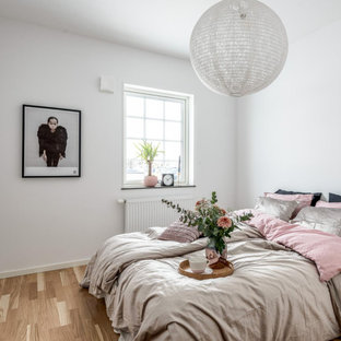 Inspiration för nordiska gästrum, med vita väggar, laminatgolv och beiget golv