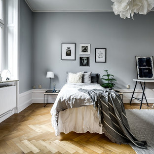 Exempel på ett nordiskt sovrum, med grå väggar, mellanmörkt trägolv och beiget golv