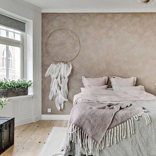 Minimalistisk inredning av ett mellanstort huvudsovrum, med beige väggar, ljust trägolv och beiget golv
