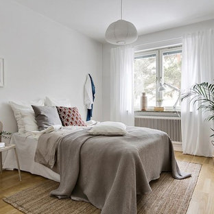 Idéer för ett nordiskt sovrum, med vita väggar, ljust trägolv och beiget golv