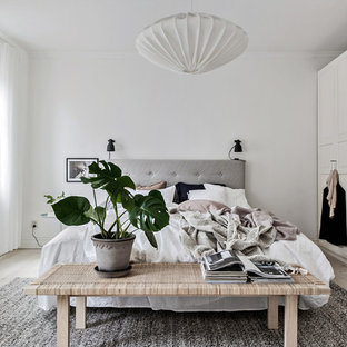 Foto på ett mellanstort skandinaviskt huvudsovrum, med vita väggar, ljust trägolv och beiget golv