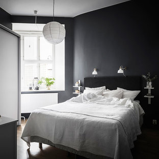 Inspiration för små skandinaviska gästrum, med svarta väggar, mellanmörkt trägolv och brunt golv